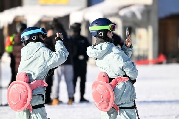 سائحون يلتقطون صورًا في منتجع للتزلج مع بدء موسم الجليد والثلوج في شنيانغ، بمقاطعة لياونينغ في الصين. - سبوتنيك عربي