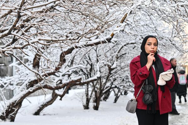 سائحة تستمتع بالمشي في شارع إيلينكا المغطى بالثلوج في العاصمة موسكو. - سبوتنيك عربي