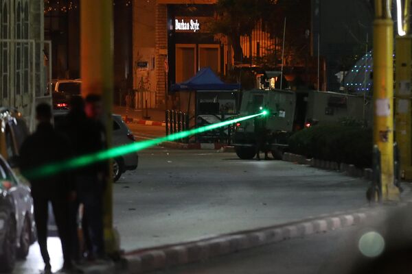 فلسطينيون يحتفلون بعد الإعلان عن اتفاق وقف إطلاق النار بين إسرائيل وحماس في الخليل، الضفة الغربية، بينما  تقتحم القوات الإسرائيلية المنطقة. - سبوتنيك عربي