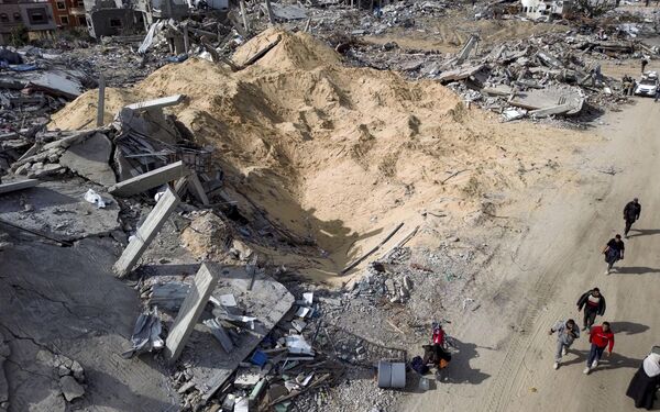صورة جوية تظهر فلسطينيين يسيرون في الدمار الذي خلفه الهجوم الجوي والبري الإسرائيلي في رفح، بعد اتفاق وقف إطلاق النار بين &quot;حماس&quot; وإسرائيل. - سبوتنيك عربي