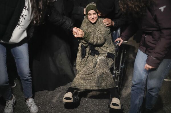 أسيرة فلسطينية على كرسي متحرك يتم استقبالها بعد نزولها من حافلة، بعد إطلاق سراحها من سجن إسرائيلي، في مدينة بيتونيا في الضفة الغربية. - سبوتنيك عربي