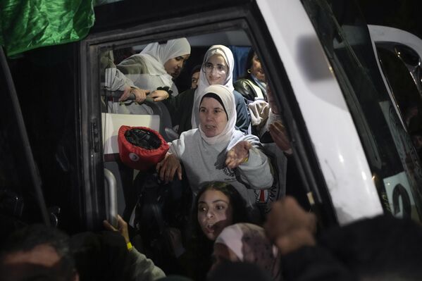 أسيرات فلسطينيات ينزلن من حافلة بعد إطلاق سراحهن من سجن إسرائيلي، في مدينة بيتونيا في الضفة الغربية. - سبوتنيك عربي