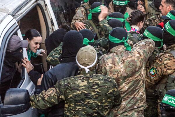 صورة تظهر عملية تسليم الرهائن الإسرائيليات إلى الصليب الأحمر من قبل عناصر &quot;حماس&quot;. - سبوتنيك عربي