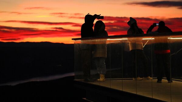 مجموعة من الناس يلتقطون الصور أثناء غروب الشمس في منصة المراقبة في نيكولاييفسكايا سوبكا، أعلى نقطة جغرافية داخل حدود مدينة كراسنويارسك. مجموعة من الناس يلتقطون الصور أثناء غروب الشمس في منصة المراقبة في نيكولاييفسكايا سوبكا، أعلى نقطة جغرافية داخل حدود مدينة كراسنويارسك. - سبوتنيك عربي