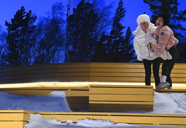 أم شابة مع طفلها وصديقتها أثناء غروب الشمس على سطح المراقبة في نيكولاييفسكايا سوبكا، أعلى نقطة جغرافية داخل مدينة كراسنويارسك. - سبوتنيك عربي