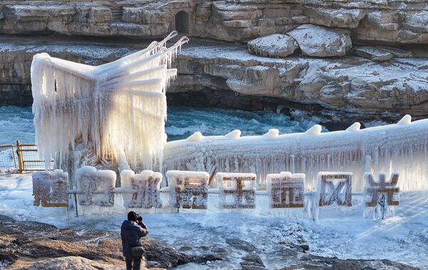 هواء الشتاء المتجمد يحول شلال هوكو إلى أرض عجائب جليدية في الأول من يناير 2025 في يانان بمقاطعة شنشي في الصين. - سبوتنيك عربي