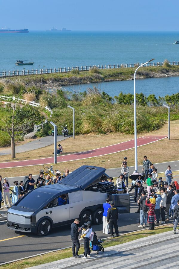 زوار يتفحصون السيارة الطائرة ويلتقطون بعض الصور بجانبها. - سبوتنيك عربي