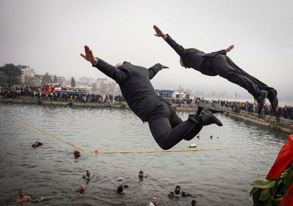 صورة لمئات المؤمنين المسيحيين الأرثوذكس وهم يسبحون للحصول على صليب ألقاه الأسقف الأرثوذكسي المقدوني "تيموتيج" في المياه المتجمدة لبحيرة أوهريد، خلال احتفال عيد الغطاس في مدينة أوهريد الجنوبية الغربية، شمال مقدونيا. - سبوتنيك عربي