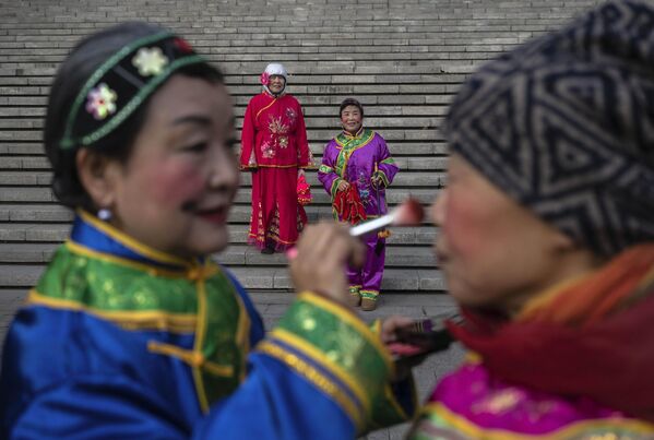 يرتدي السكان المحليون أزياء تقليدية أثناء استعدادهم لموكب صغير للعام الصغير، أو شياونيان، الذي يمثل بداية الاستعدادات للعام القمري الجديد ومهرجان الربيع، في بكين، الصين. - سبوتنيك عربي