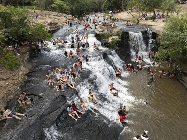 أشخاص يستجمون في مجرى مائي في نهر سالتوس ديل بيراريتا في فترة ما بعد الظهر الصيفية في بيريبيوي، باراغواي. - سبوتنيك عربي