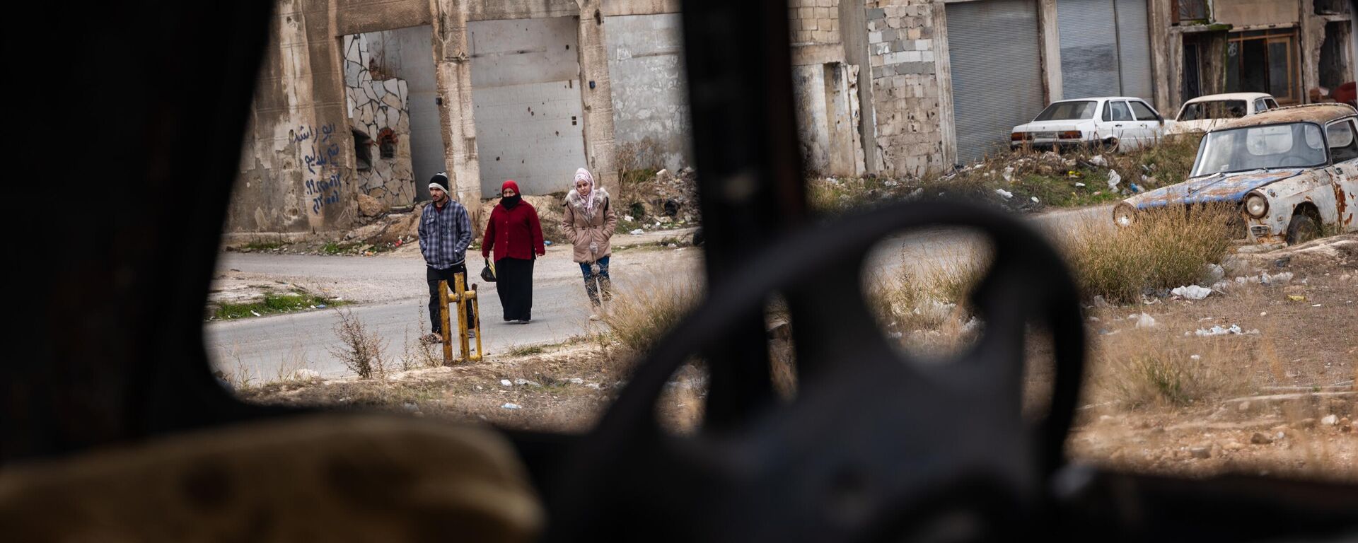يسير الناس عبر حي تضرر بشدة بعد سنوات من الحرب في مدينة حمص في 22 يناير 2025 في حمص، سوريا - سبوتنيك عربي, 1920, 07.05.2025