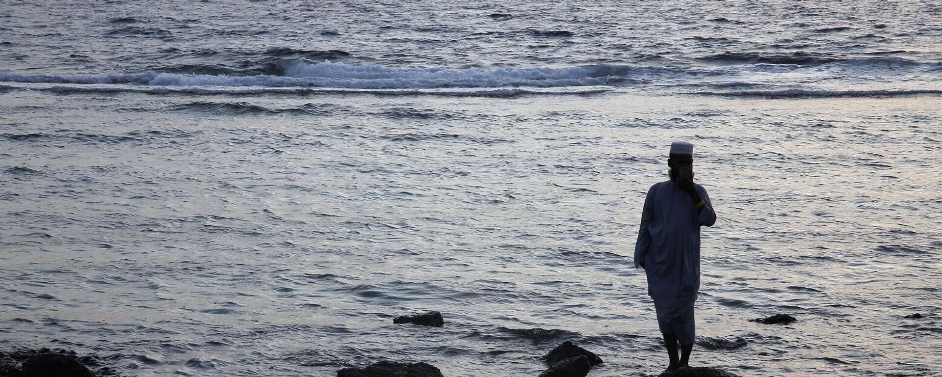 رجل يقف على صخرة أثناء التقاط صورة سيلفي أثناء زيارة لشاطئ البحر الأحمر في جدة بالمملكة العربية السعودية - سبوتنيك عربي, 1920, 26.01.2025