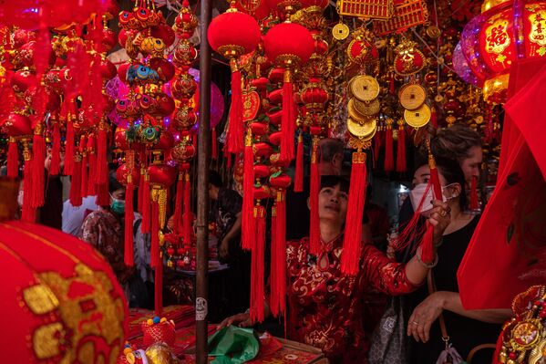 نساء يضعن الزينة خلال مهرجان رأس السنة القمرية الصينية، في متجر في الحي الصيني قبل حلول رأس السنة القمرية الصينية في بانكوك. - سبوتنيك عربي
