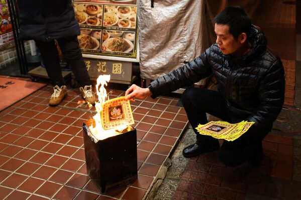 رجل يحرق بعض الأوراق للاحتفال بالعام الصيني الجديد في يوكوهاما باليابان - سبوتنيك عربي
