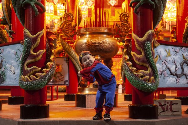 صبي يرتدي ملابس صينية تقليدية يقف أمام معبد عشية رأس السنة الصينية في جاكرتا بإندونيسيا - سبوتنيك عربي