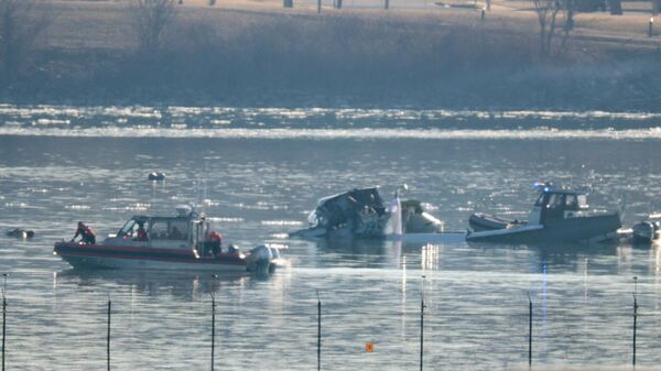 تبحث وحدات الاستجابة للطوارئ في موقع تحطم طائرة تابعة لشركة الخطوط الجوية الأمريكية على نهر بوتوماك بعد حادث وقع الليلة الماضية أثناء اقترابها من مطار رونالد ريغان الوطني - سبوتنيك عربي