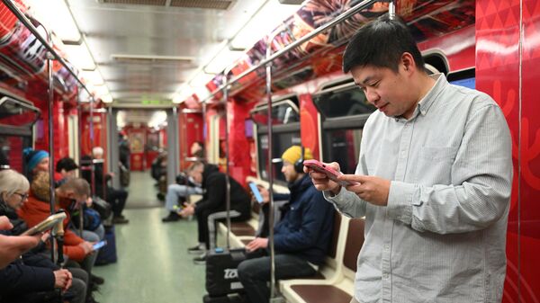 ركاب على متن القطار الذي يحمل عنوان السنة الصينية الجديدة في موسكو. ويصور على الجزء الخارجي من العربات ثعبان وتنين صيني، وفي الداخل يمكن للركاب مشاهدة صور احتفالات رأس السنة الجديدة في الصين. - سبوتنيك عربي