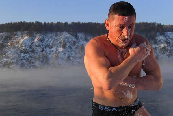 يمسح أوليغ فولكوف، المتحمس للسباحة الشتوية والتحمل، نفسه بالثلج بعد سباحة يومية في نهر ينيسي عند درجة حرارة -26 درجة في مقاطعة كراسنويارسك. - سبوتنيك عربي