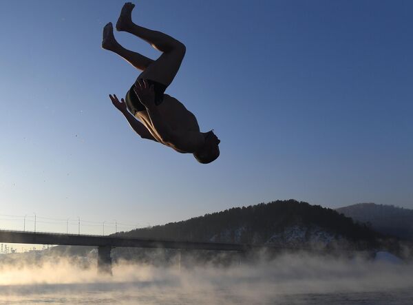 أوليغ فولكوف، وهو من عشاق السباحة الشتوية والتصلب، أثناء سباحته اليومية في نهر ينيسي. - سبوتنيك عربي