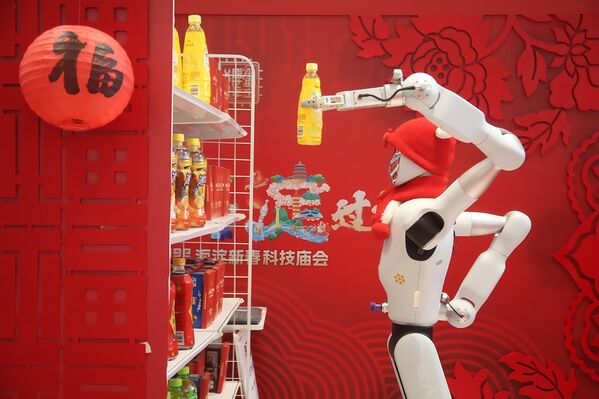 روبوت يقوم بترتيب الرفوف خلال عرض فني لروبوتات في معرض للعلوم والتكنولوجيا في بكين في الصين - سبوتنيك عربي