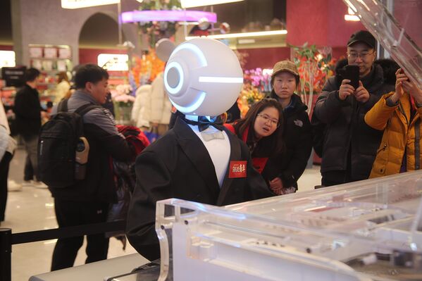 زوار يشاهدون ويصورون روبوتا يؤدي عرضًا في معرض للعلوم والتكنولوجيا في بكين في الصين - سبوتنيك عربي
