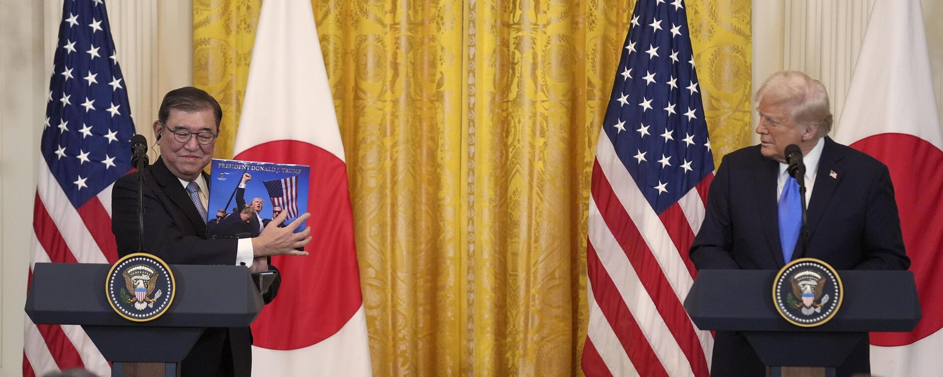 رئيس الوزراء الياباني شيجيرو إيشيبا يحمل كتابًا قدمه للرئيس دونالد ترامب خلال مؤتمر صحفي في البيت الأبيض، الجمعة 7 فبراير 2025 - سبوتنيك عربي, 1920, 08.02.2025