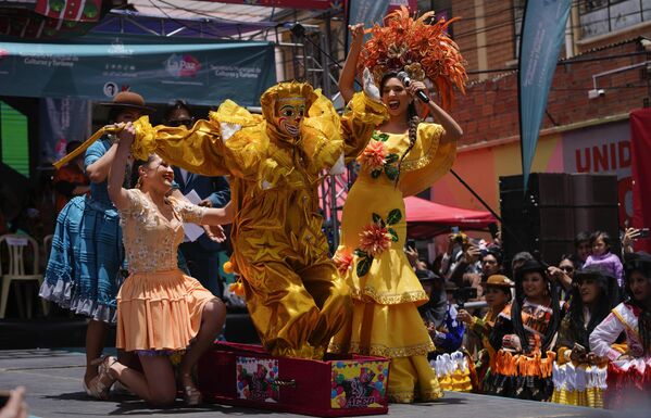 فتاة تساعد رجلاً يرتدي زي بيبينو، وهي شخصية تمثل الفرح، حيث ينهض من نعشه خلال مراسم الكرنفال. - سبوتنيك عربي