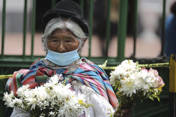 امرأة تبيع الزهور خلال فعاليات المهرجان في مقبرة لاباز. - سبوتنيك عربي