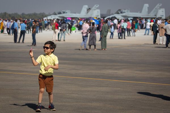 طفل يحمل بيده طائرة صغيرة خلال تجوله في مدرجات المطار خلال فعاليات المعرض - سبوتنيك عربي