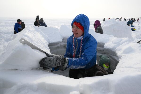 شابة تشارك  في بناء الأكواخ الثلجية في نوفوسيبيرسك - سبوتنيك عربي