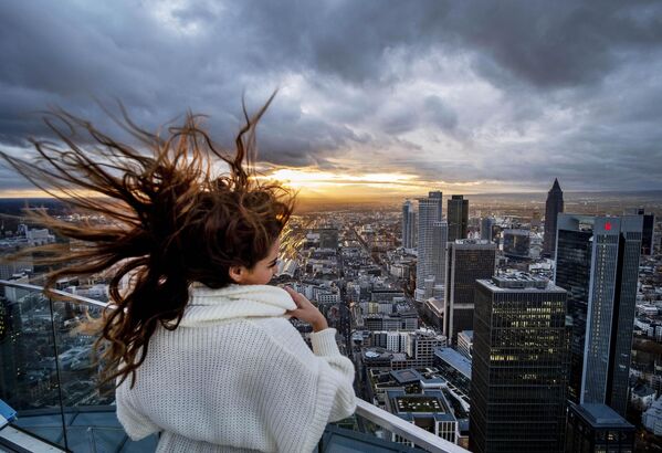 تطاير شعر سائحة فرنسية شابة مع غروب الشمس على منصة المشاهدة في "برج ماين"، فرانكفورت بألمانيا - سبوتنيك عربي