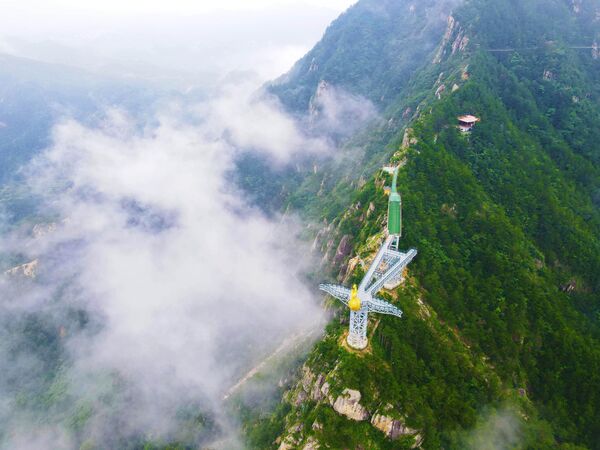 صورة جوية تُظهر منصة عرض "فينيكس لوف" الزجاجية في منطقة فيتشيزهاي ذات المناظر الطبيعية الخلابة محاطة بالغيوم في مقاطعة يويكس بمدينة أنكينغ، الصين - سبوتنيك عربي