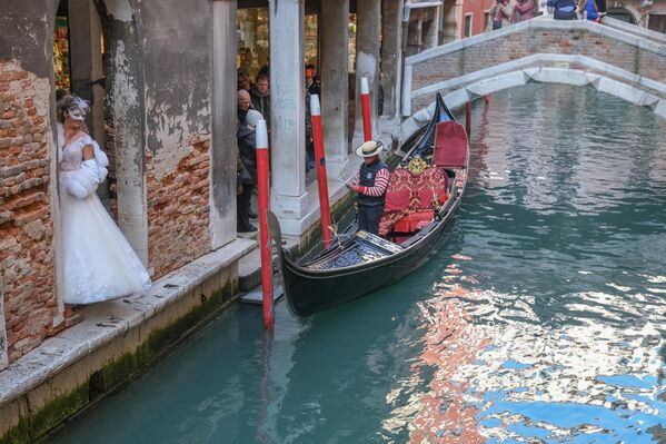 سائح مقّنع يوقف قاربه لالتقاط صورة خلال كرنفال البندقية، إيطاليا. - سبوتنيك عربي