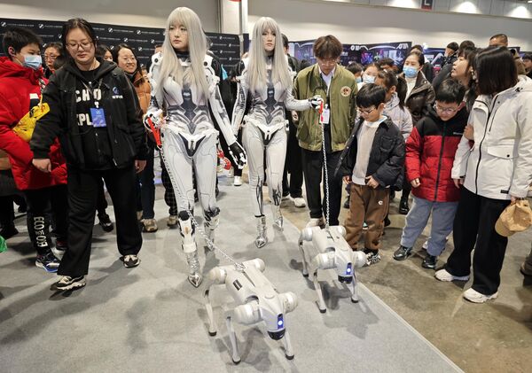 فريق علمي يقود كلابًا آلية، خلال معرض الروبوتات الذكية 2025، في مركز نانجينغ الدولي للمعارض بمقاطعة جيانغسو في الصين - سبوتنيك عربي