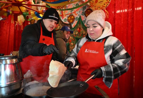 بائعون يطهون فطائر &quot;بليني&quot; الشهية في عيد &quot;ماسلينيتسا&quot;، خلال فعاليات مهرجان &quot;الشتاء في موسكو&quot; في ساحة &quot;مانيجنايا&quot;، بالعاصمة موسكو - سبوتنيك عربي