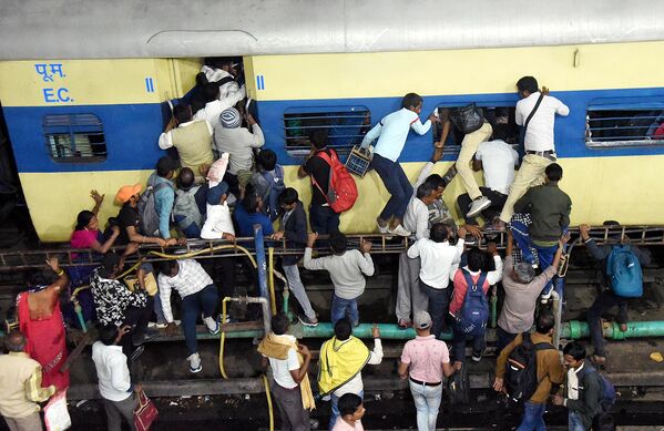 ركاب يتدافعون للصعود على متن قطار مكتظ وسط ازدحام، بسبب مهرجان &quot;براياغراج ماهاكومبه ميلا&quot; في باتنا، الهند. - سبوتنيك عربي