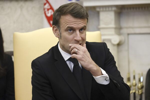 الرئيس الفرنسي إيمانويل ماكرون، يضع يده على وجهه وهو يستمع خلال اجتماع مع الرئيس دونالد ترامب، في البيت الأبيض في واشنطن - سبوتنيك عربي