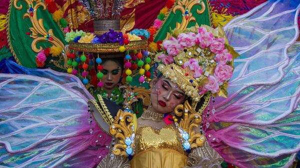 مشاركون يرتدون أزياء الكرنفال يأخذون قيلولة خلال كرنفال في باندونغ بإندونيسيا - سبوتنيك عربي