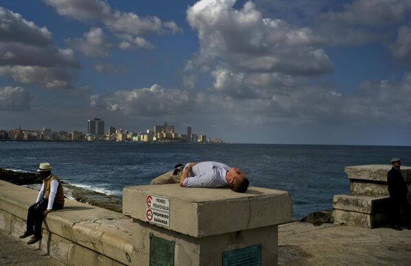 سائح ينام على الواجهة البحرية في هافانا في كوبا - سبوتنيك عربي