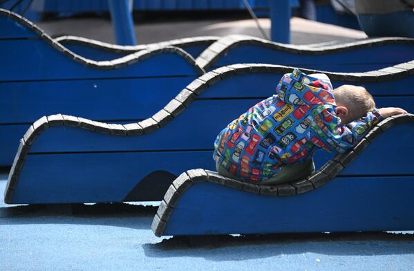 طفل نائم على مقعد في حديقة غوركي المركزية للثقافة والترفيه في موسكو - سبوتنيك عربي