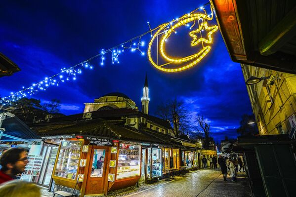 صورة تظهر تزيين أجزاء مختلفة من سوق &quot;باسكارسييا&quot; التاريخي القديم بالأضواء مع أشكال القمر والنجوم استعدادًا لشهر رمضان، في العاصمة سراييفو، البوسنة والهرسك. - سبوتنيك عربي