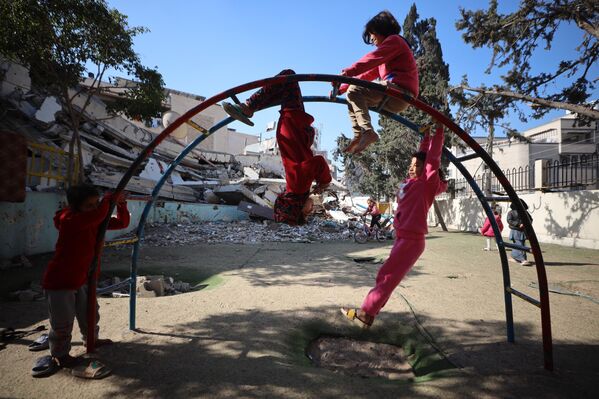 أطفال فلسطينيون يلعبون في مدرسة متضررة وسط وقف إطلاق النار بين إسرائيل و"حماس" في مدينة غزة، 26 فبراير 2025. - سبوتنيك عربي