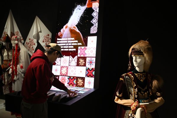 أحد الزوار يعاين شاشة رقمية في إحدى زاويا معرض &quot;رحلة عبر روسيا&quot; في مركز روسيا الوطني. - سبوتنيك عربي