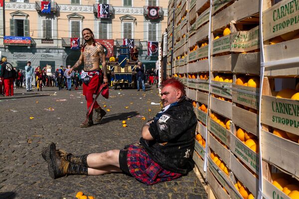 أعضاء فرق معركة البرتقال يشاركون في معركة البرتقال التقليدية في إيفريا بإيطاليا في 4 مارس 2025. يجري هذا الحدث، وهو أكبر معركة طعام في إيطاليا، خلال موسم الكرنفال ويرمز إلى ثورة تاريخية حدثت في إيفريا خلال العصور الوسطى. - سبوتنيك عربي