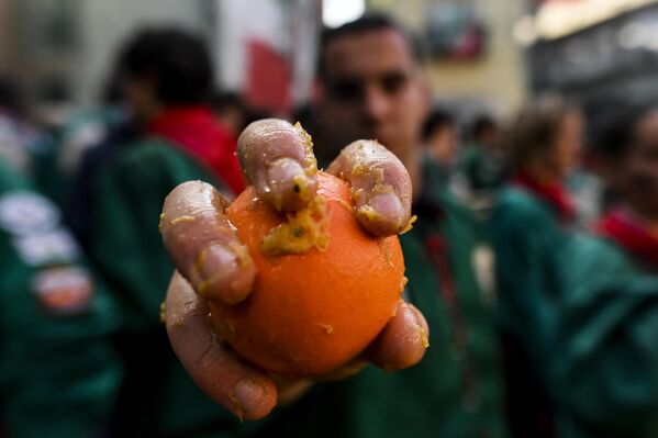 رجل من "I Tuchini del Borghetto Aranceri" يعرض برتقالة في يده قبل "معركة البرتقال" التقليدية في 4 مارس 2025 في إيفريا، إيطاليا. - سبوتنيك عربي