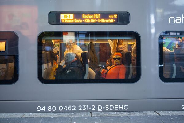 مشاركون في كرنفال يستقلون قطارًا في المحطة الرئيسية في دوسلدورف بألمانيا - سبوتنيك عربي