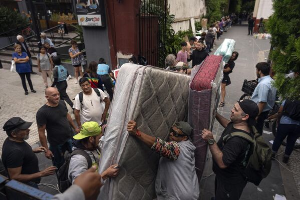 متطوعون يحملون شاحنة بالمواد المتبرع بها للأشخاص المتضررين من الفيضانات في كنيسة كاكوبي في بوينس آيرس، الأرجنتين. - سبوتنيك عربي