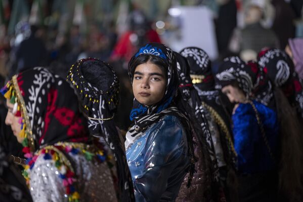 امرأة إيرانية كردية ترتدي أزياءً تقليدية، وتنتظر أداءً في احتفال النوروز في ساحة آزادي غربي طهران - سبوتنيك عربي