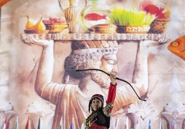 امرأة إيرانية ترتدي أزياءً تقليدية وتؤدي عروضًا احتفالية في احتفال النوروز في ساحة آزادي غربي طهران - سبوتنيك عربي