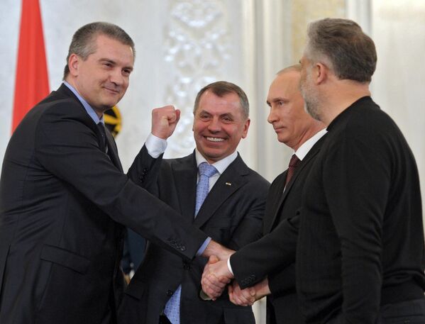 صورة التقطت بتاريخ 18 مارس 2014، ويظهر الرئيس الروسي فلاديمير بوتين (الثاني من اليمين) في الكرملين خلال حفل توقيع الاتفاق بين روسيا الاتحادية وجمهورية القرم بشأن انضمام جمهورية القرم إلى روسيا الاتحادية. ويقف من اليسار إلى اليمين، رئيس وزراء جمهورية القرم سيرغي أكسينوف، رئيس مجلس الدولة لجمهورية القرم فلاديمير كونستانتينوف، وعلى اليمين رئيس سيفاستوبول أليكسي تشالي. - سبوتنيك عربي